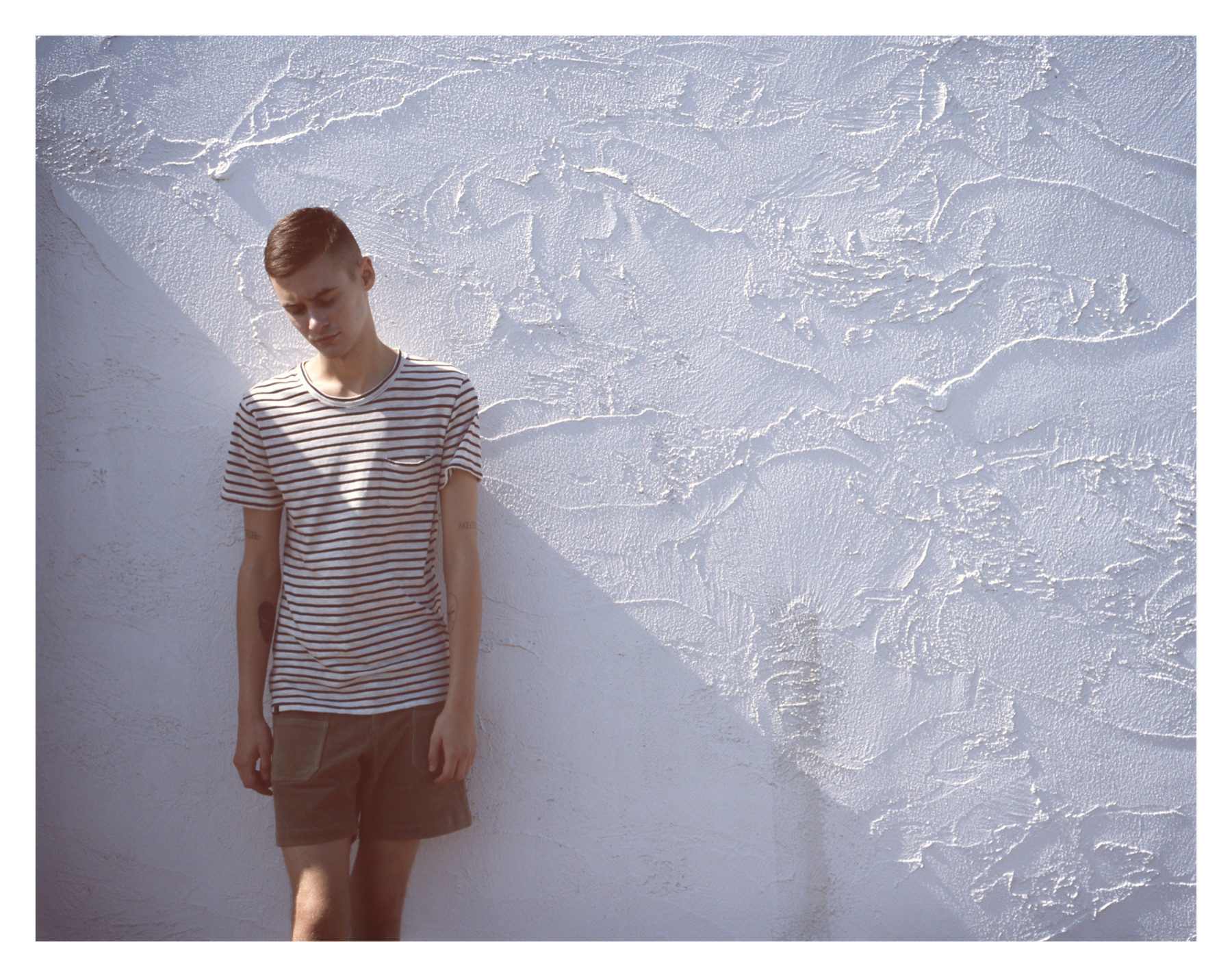 Striped T-shirt against a white textured wall